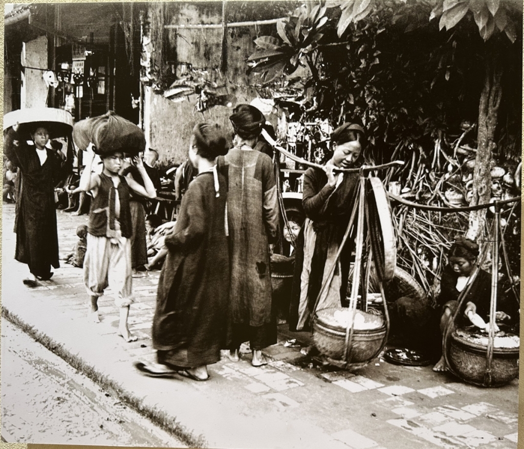 Những phụ nữ bán hàng ăn trên các đôi quang gánh ở vỉa hè trước năm 1932.